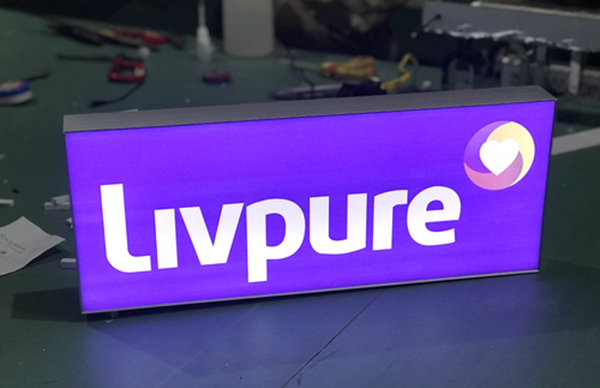 Một biển hiệu hộp đèn bằng mica hút nổi được in UV, phát sáng rực rỡ vào ban đêm, thu hút sự chú ý trên một con phố sầm uất