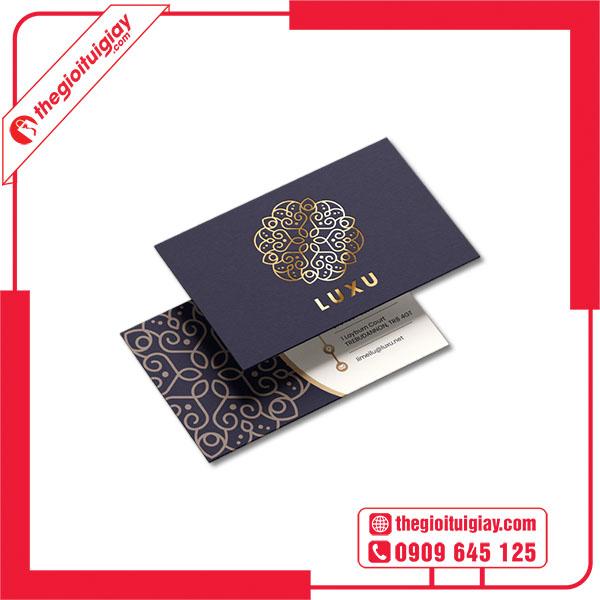 Máy ép kim đang gia công logo màu vàng đồng lên một chiếc danh thiếp làm từ giấy Bristol dày, tạo ra hiệu ứng sang trọng