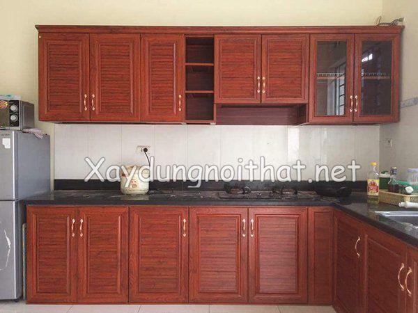 Cận cảnh so sánh chi tiết giữa một miếng Inox vàng xước và một tấm gỗ sồi khắc laser làm biển hiệu